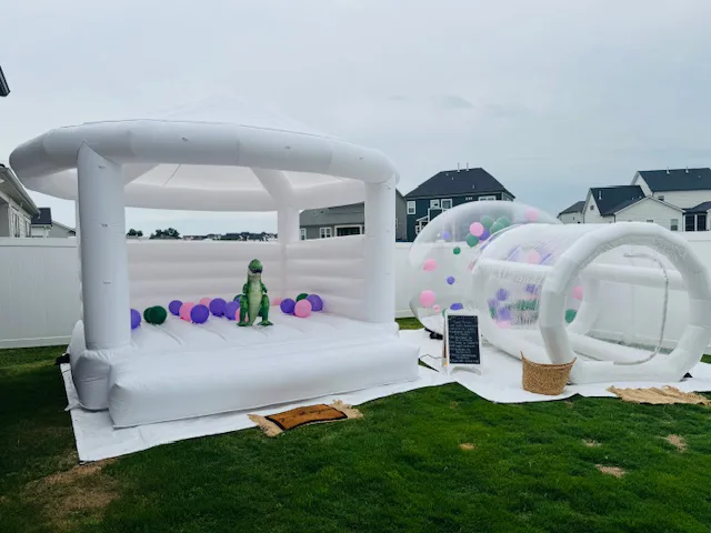 A bubble house and white bounce castle styled together